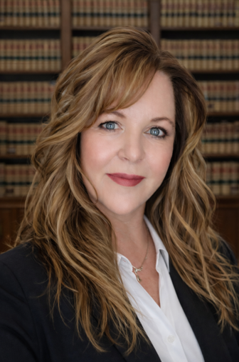 Woman with fair skin and light brown hair looking at the camera.