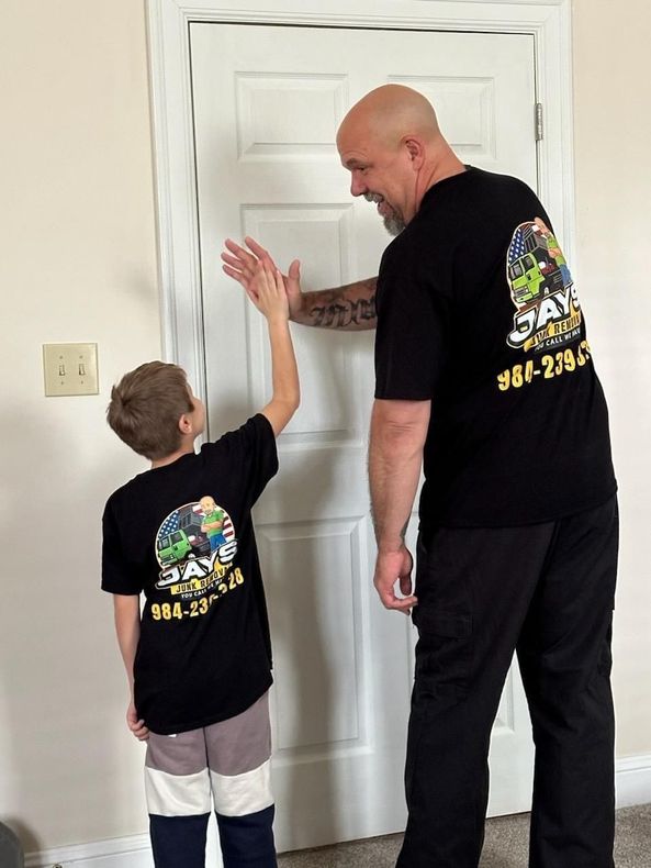 A man and a boy are standing next to each other in front of a door.