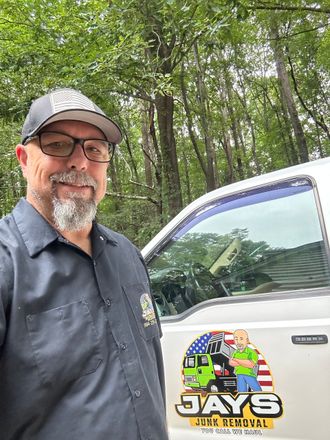 Picture of the owner of Jay's Junk Removal standing next to his truck.