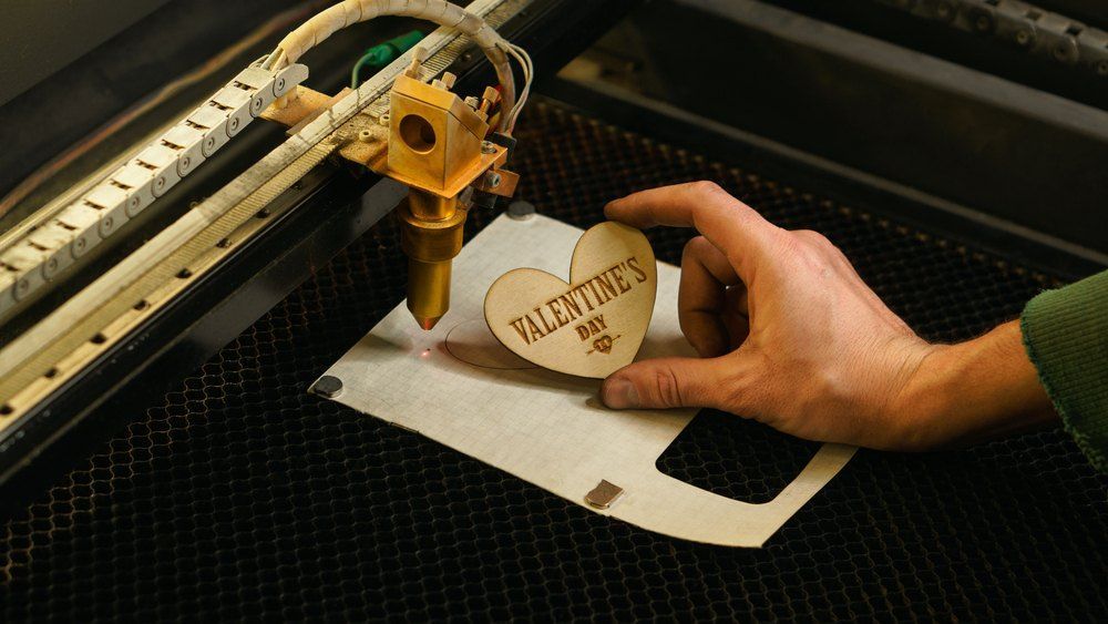 A Person is Cutting a Wooden Heart With the Words Valentine 's Day on It — Signtek Gladstone in Gladstone Central, QLD