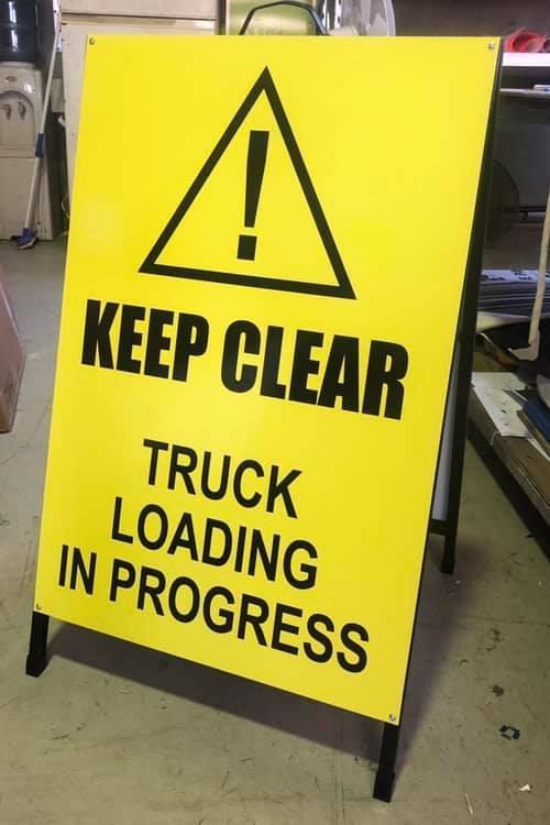 A Yellow Sign That Says Keep Clear Truck Loading in Progress — Signtek Gladstone in Gladstone Central, QLD