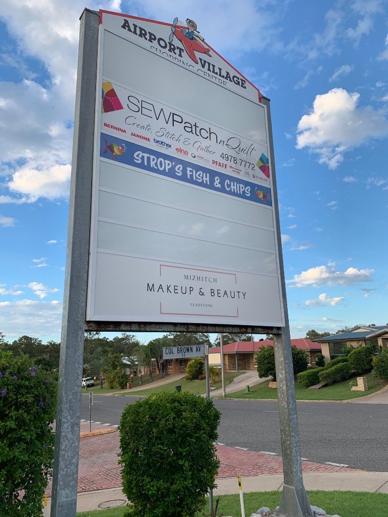 A Sign for Airport Village is Sitting on the Side of the Road — Signtek Gladstone in Gladstone Central, QLD
