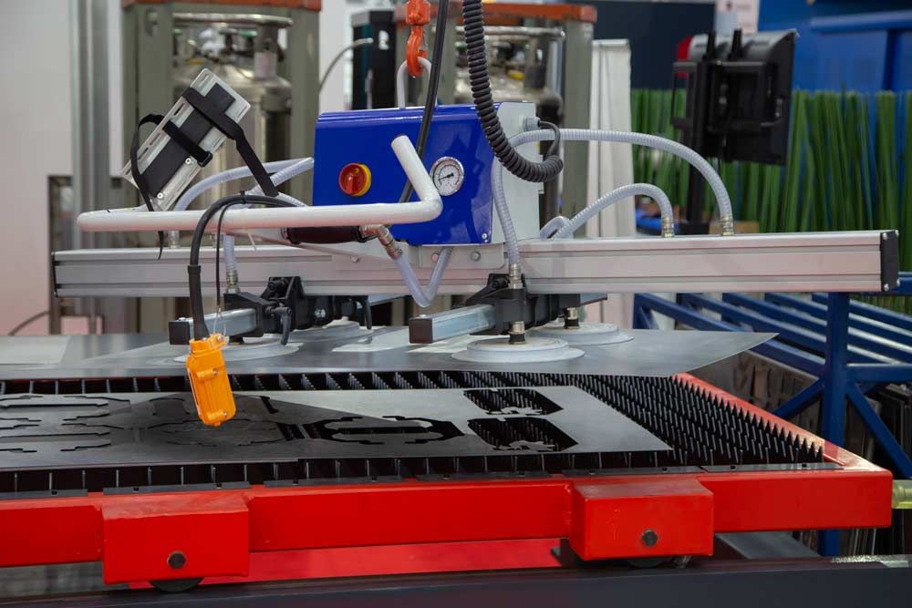 A Machine is Lifting a Piece of Metal on a Table — Signtek Gladstone in Gladstone Central, QLD