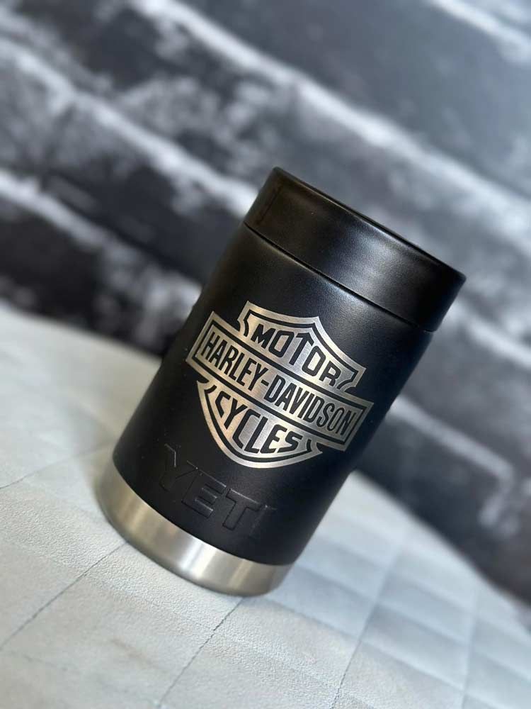 A black harley davidson can holder is sitting on a table.