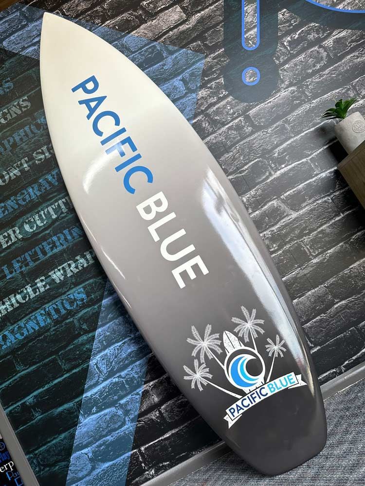 A Surfboard is Sitting in Front of a Brick Wall — Signtek Gladstone in Gladstone Central, QLD