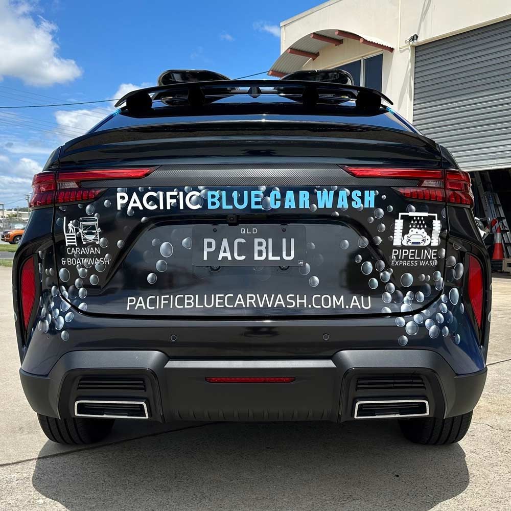 The back of a black car with pacific blue car wash written on it