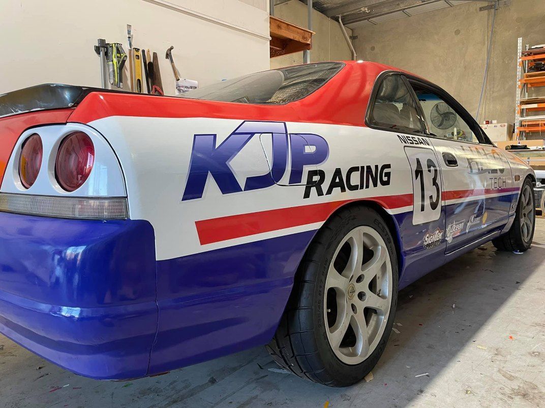 A Red White and Blue Racing Car is Parked in a Garage — Signtek Gladstone in Gladstone Central, QLD