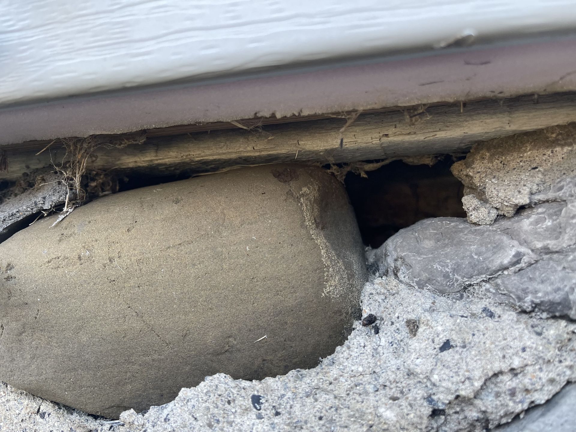 A close up of a rock in a hole in a wall.