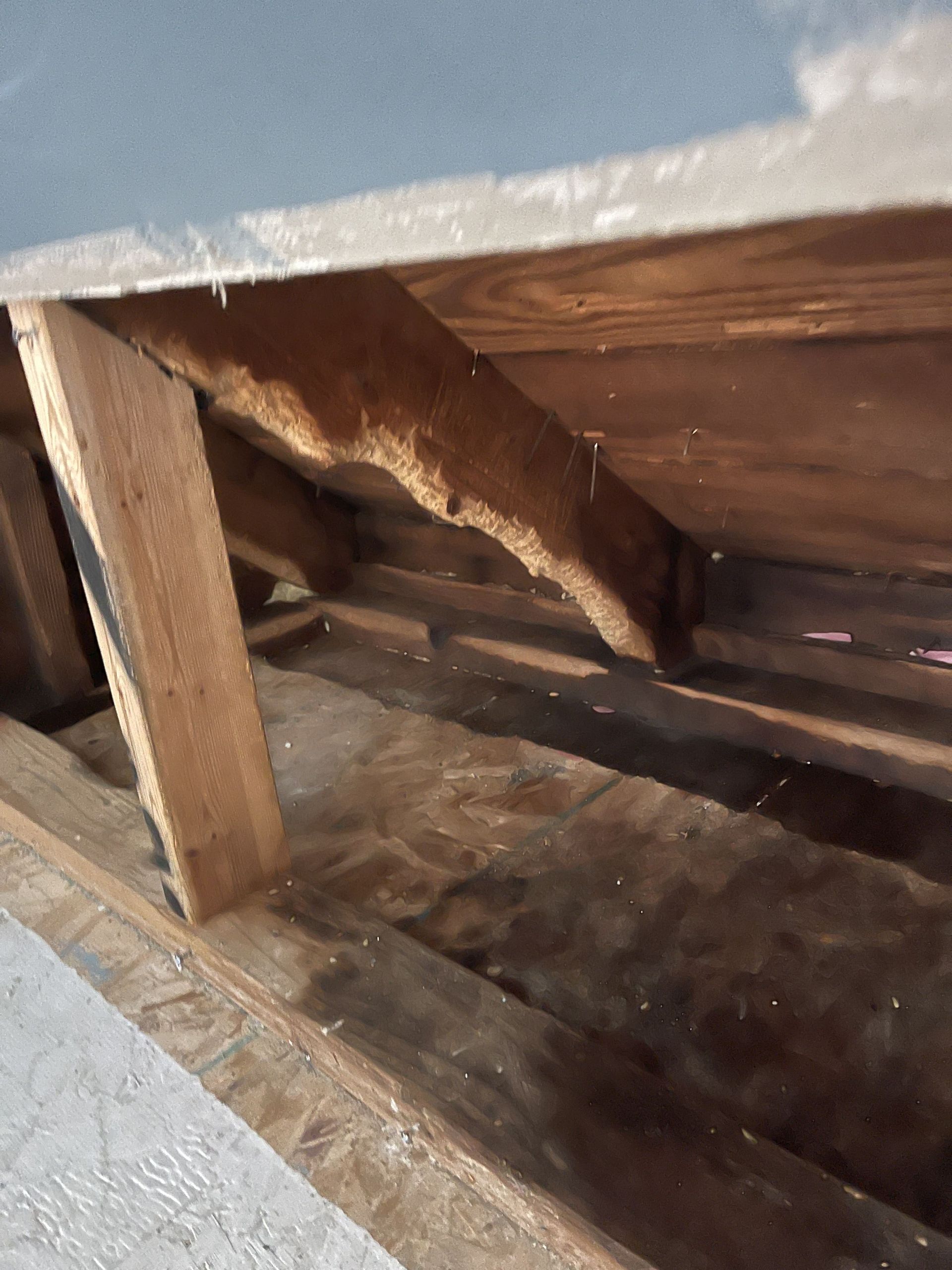 A close up of a wooden structure with a roof in the background.
