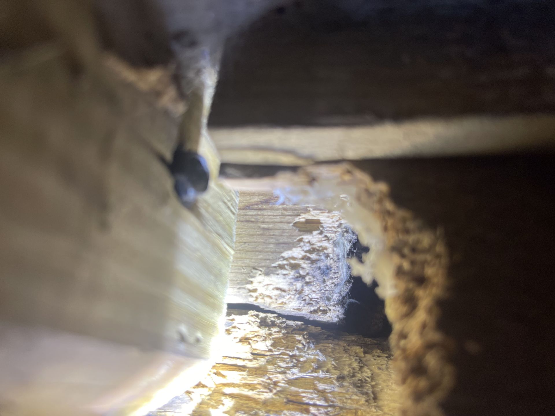 A close up of a hole in a wall with a light shining through it.