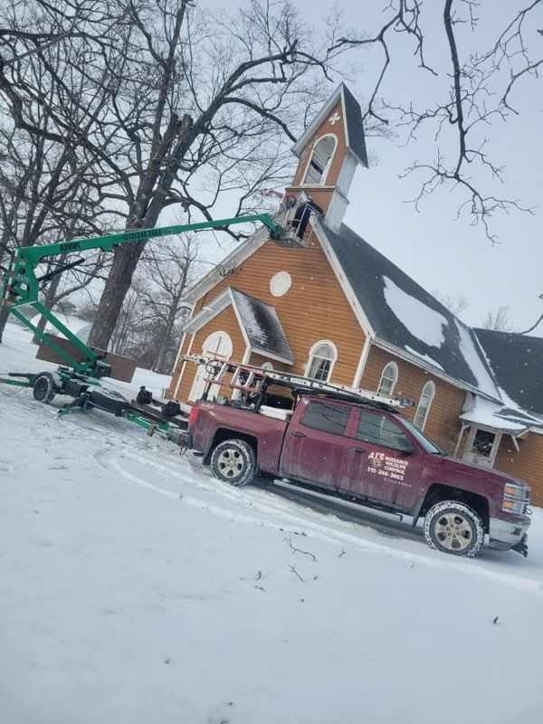 Truck with lift repairs church steeple in snow.