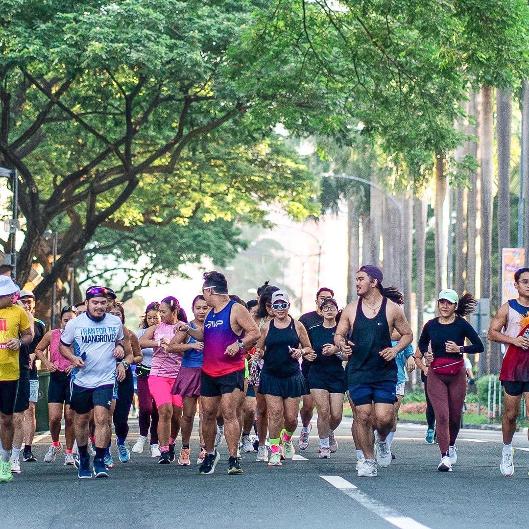 A group of people are running down a street in Makati