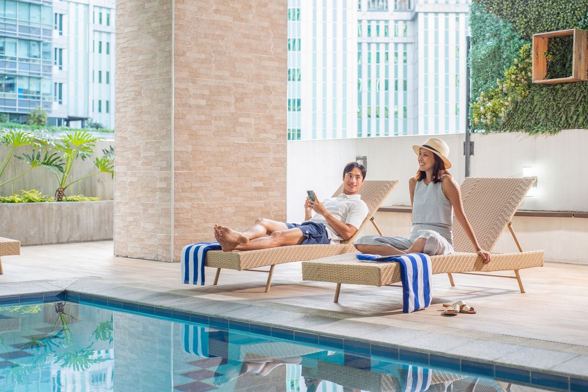 Relaxing by the pool at Salcedo Makati Hotel's serviced residences.