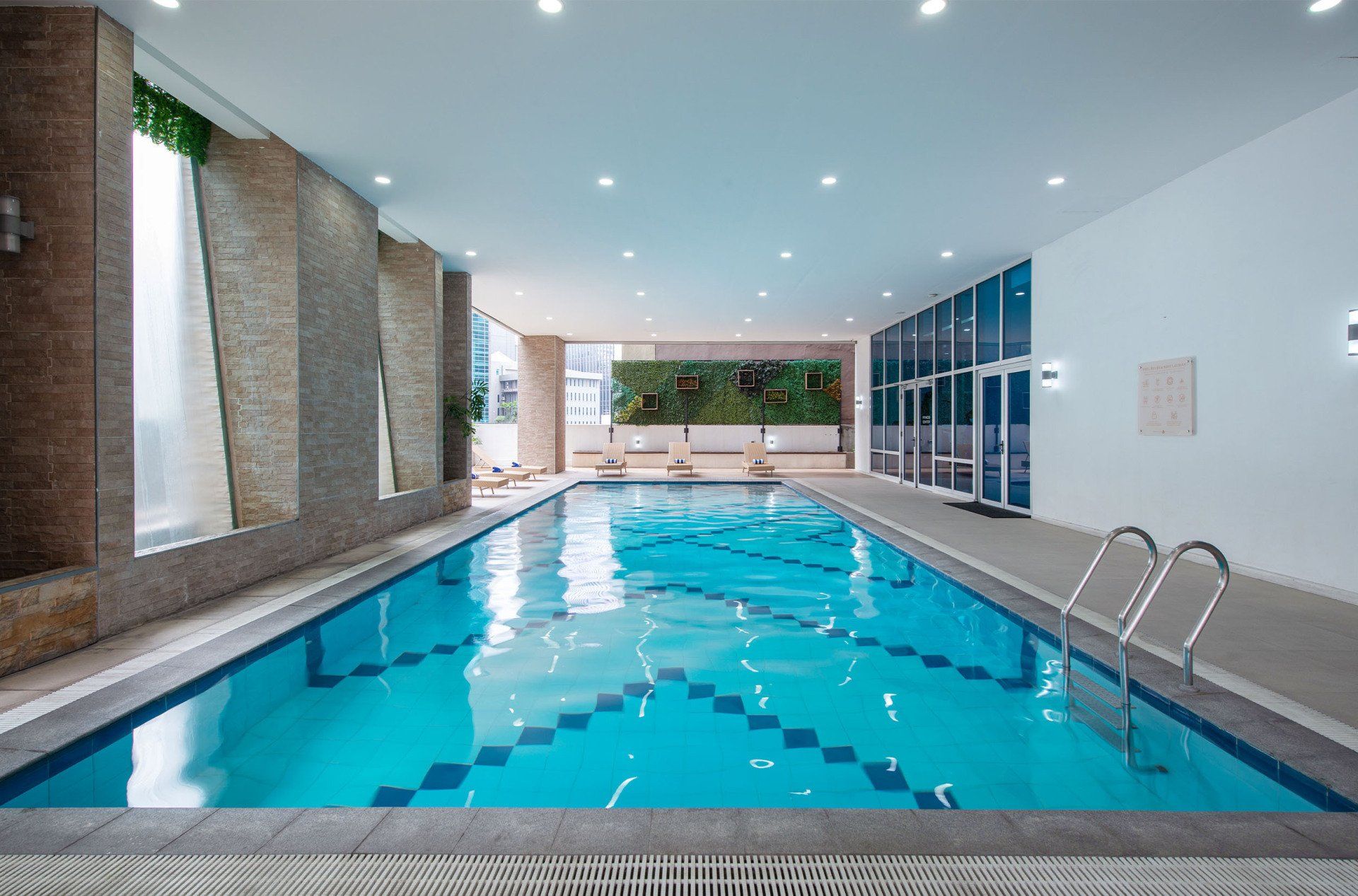 There is a large indoor swimming pool in the middle of a building.