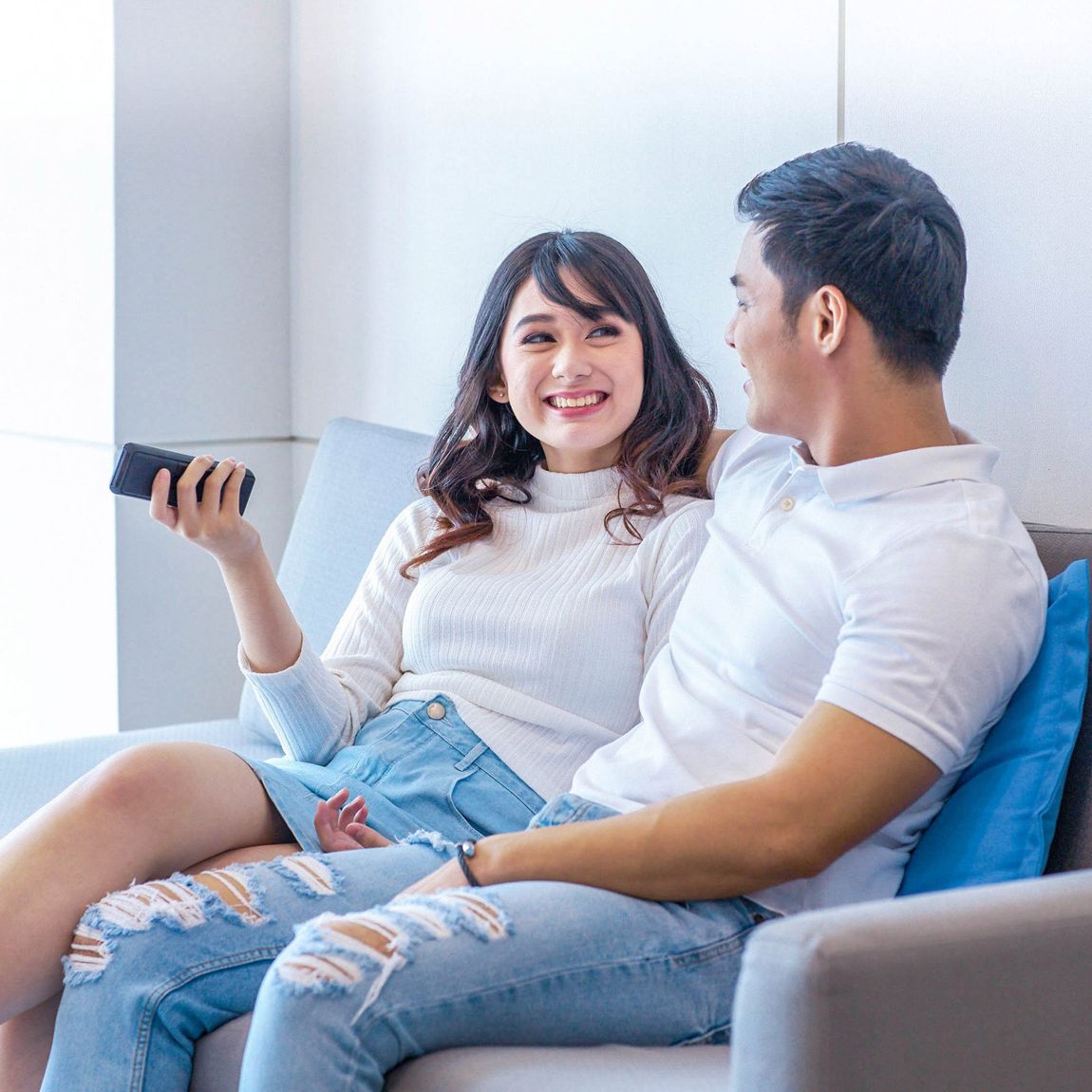 A couple relaxing on a couch in a serviced residence at Salcedo Makati Hotel