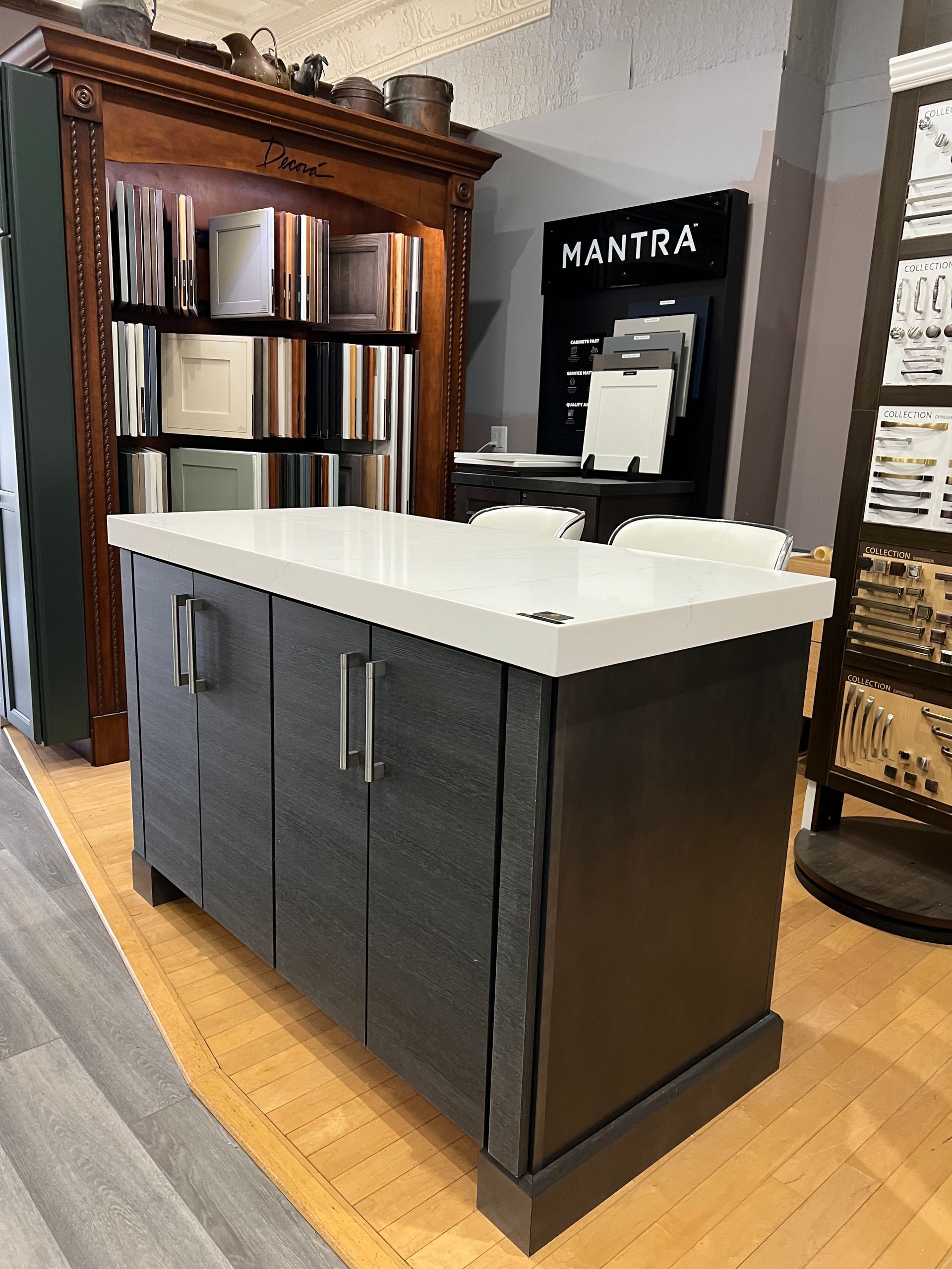 A kitchen island with a white counter top in front of a mantra sign