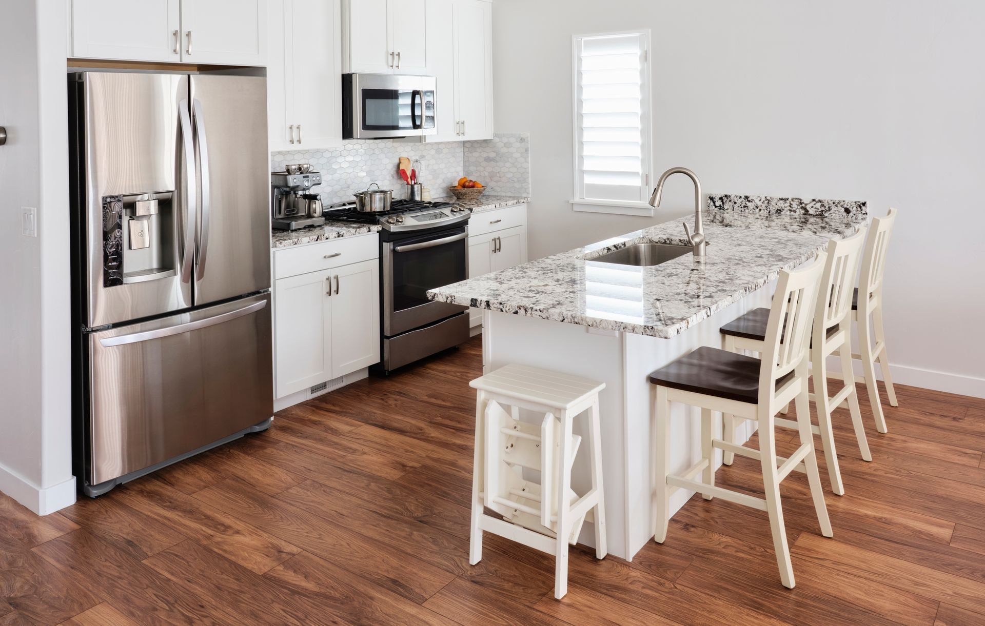 A kitchen with stainless steel appliances and granite counter tops.