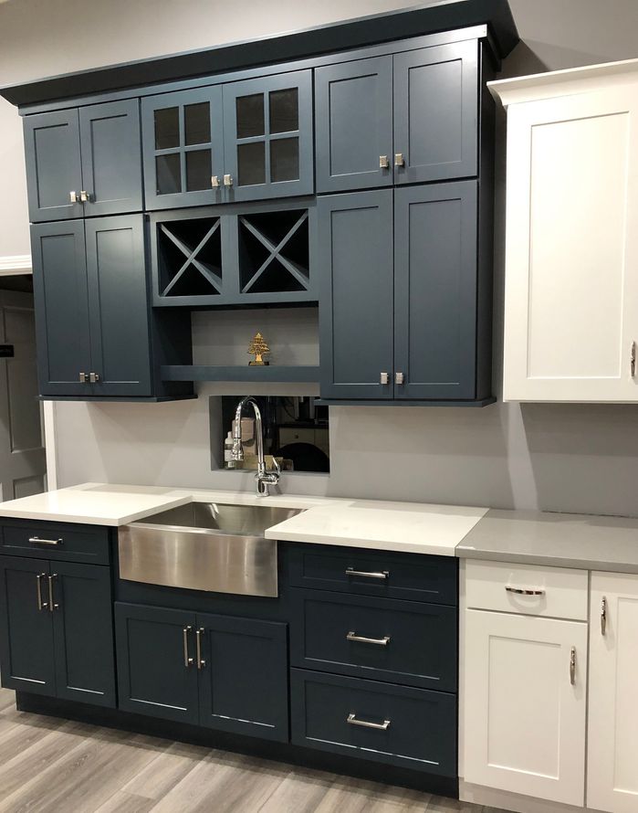 A kitchen with blue cabinets and a stainless steel sink.