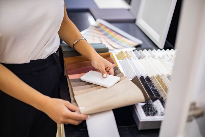 A woman is holding a swatch of fabric in a store.