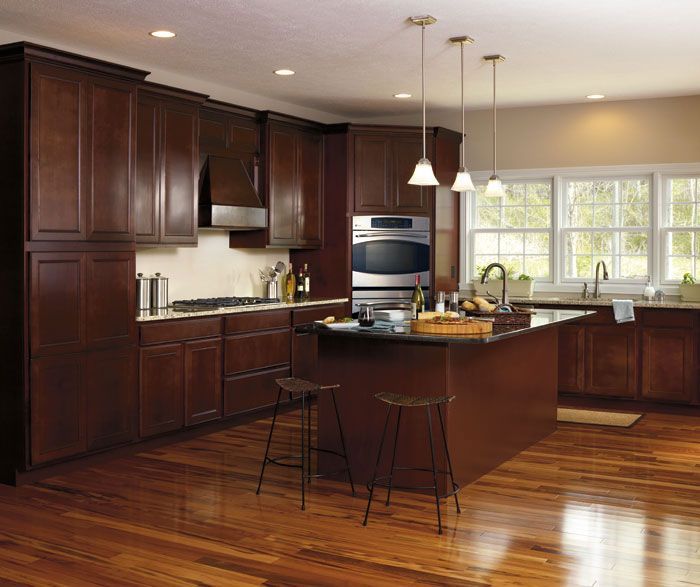 A kitchen with wooden cabinets and a large island