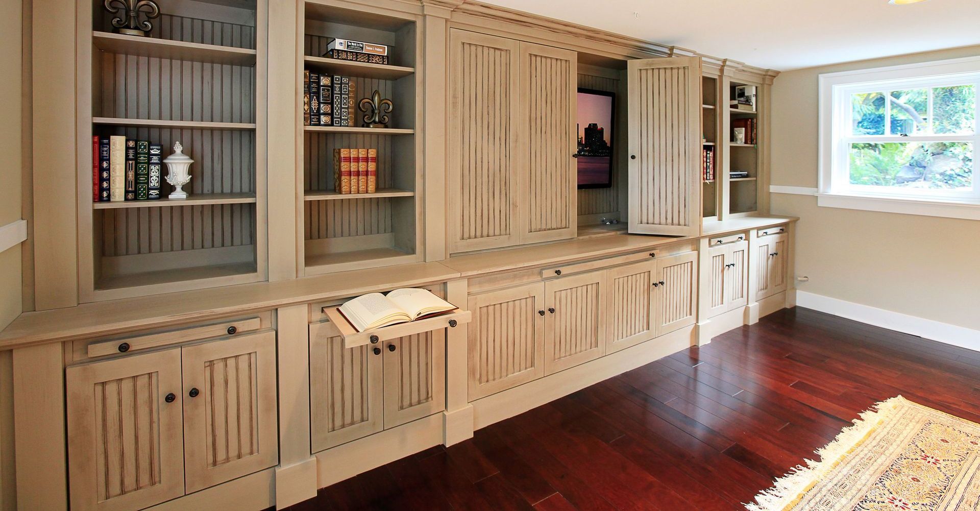 A room with a lot of shelves and cabinets and a rug on the floor.