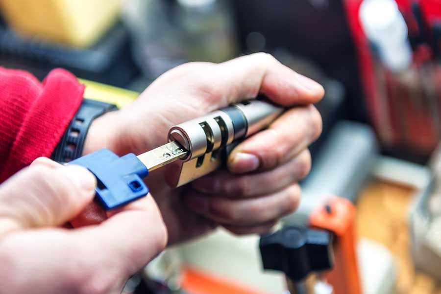 Una persona tiene in mano una chiave e un lucchetto.