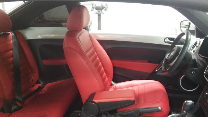 The inside of a car with red seats and a steering wheel