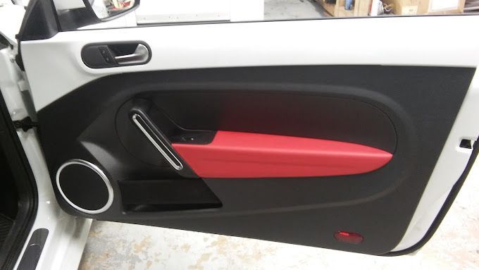 A white car with red trim on the door handles