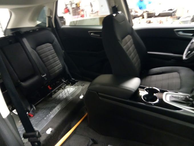 The back seat of a car with the seat belts on