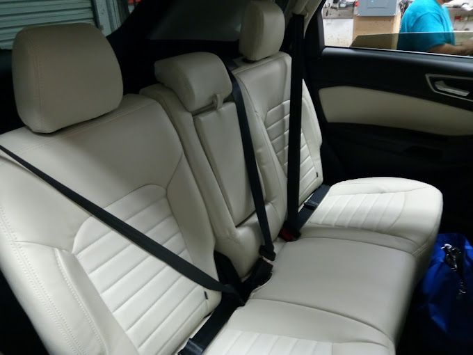 The back seat of a car with seat belts on