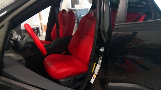 A black car with red seats and a red steering wheel