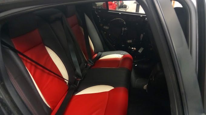 The back seat of a car with red and white seats