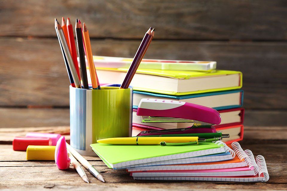 quaderni, penne, pastelli, libri e pinzatrice