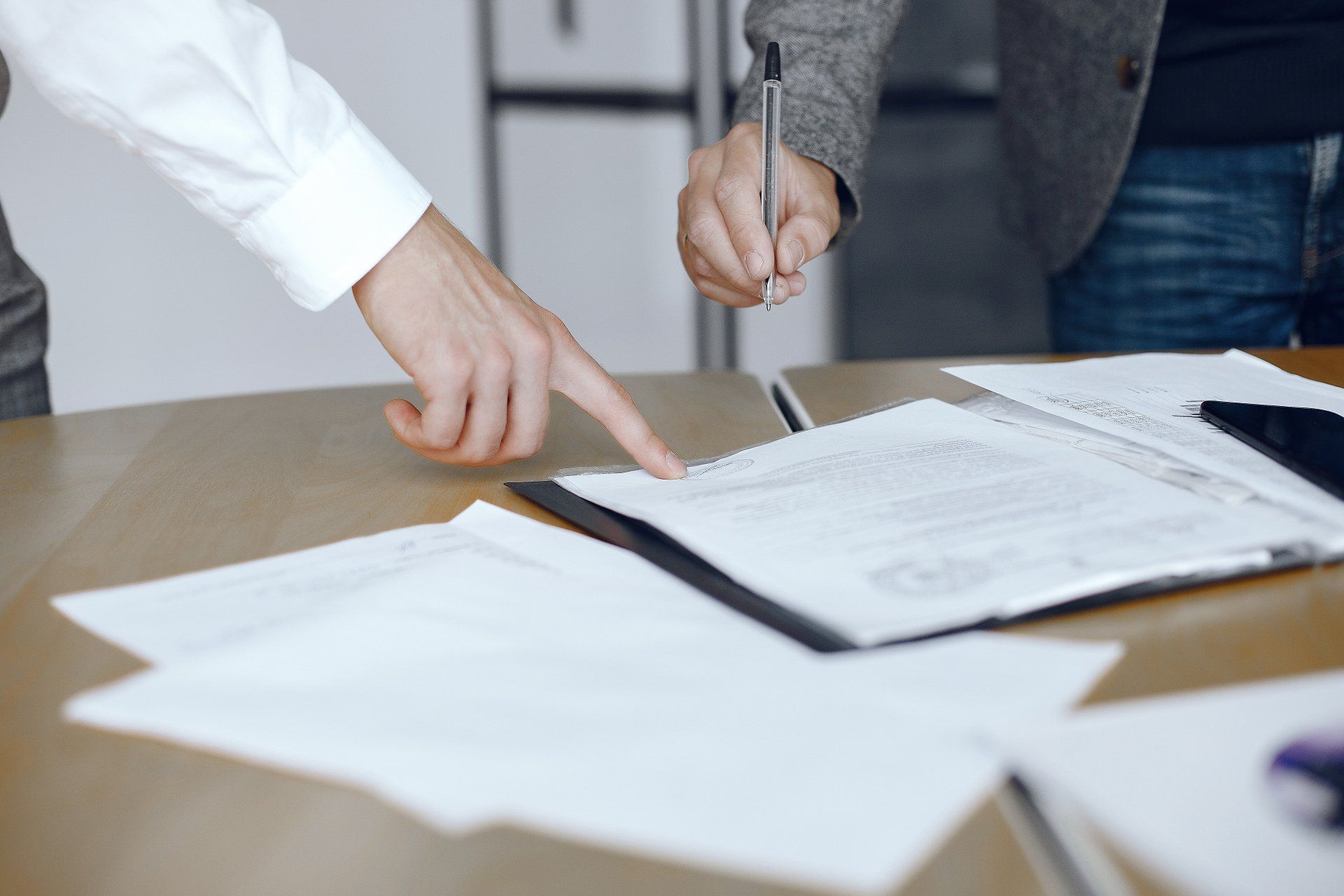man pointing at papers with information on it