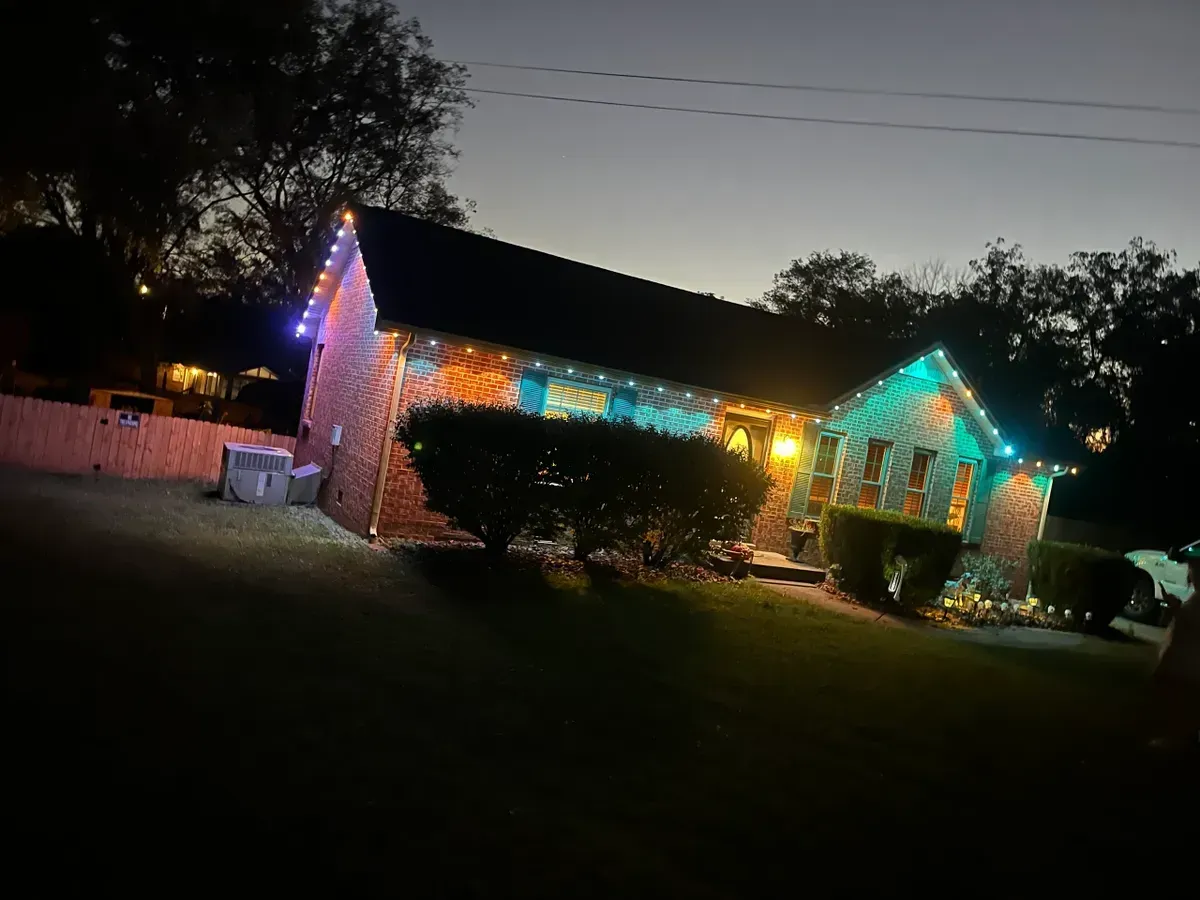 A house is lit up with christmas lights at night.