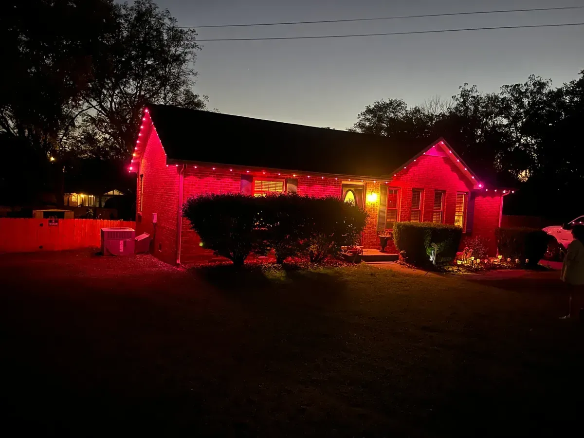 A house is lit up with red lights at night.