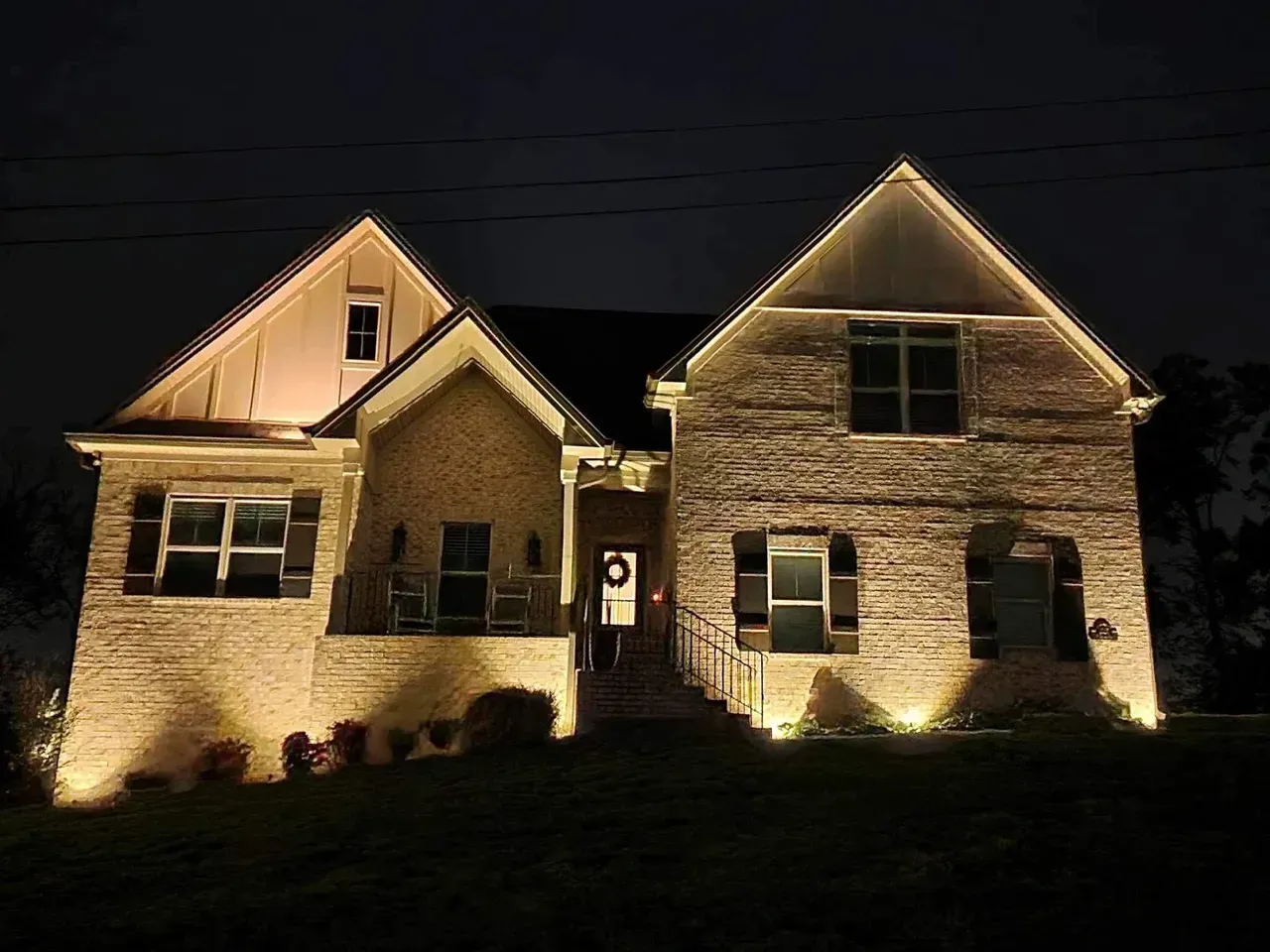 A large brick house is lit up at night.