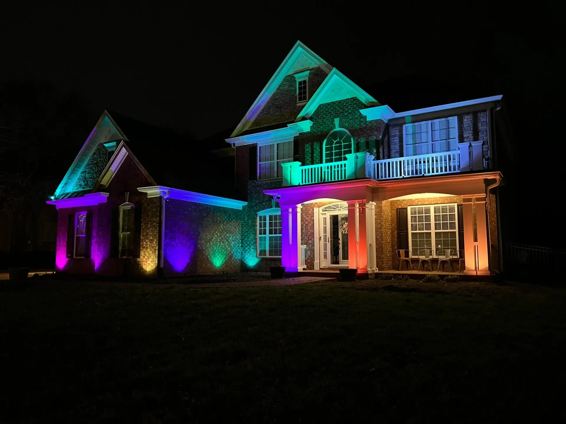 A house is lit up with rainbow lights at night