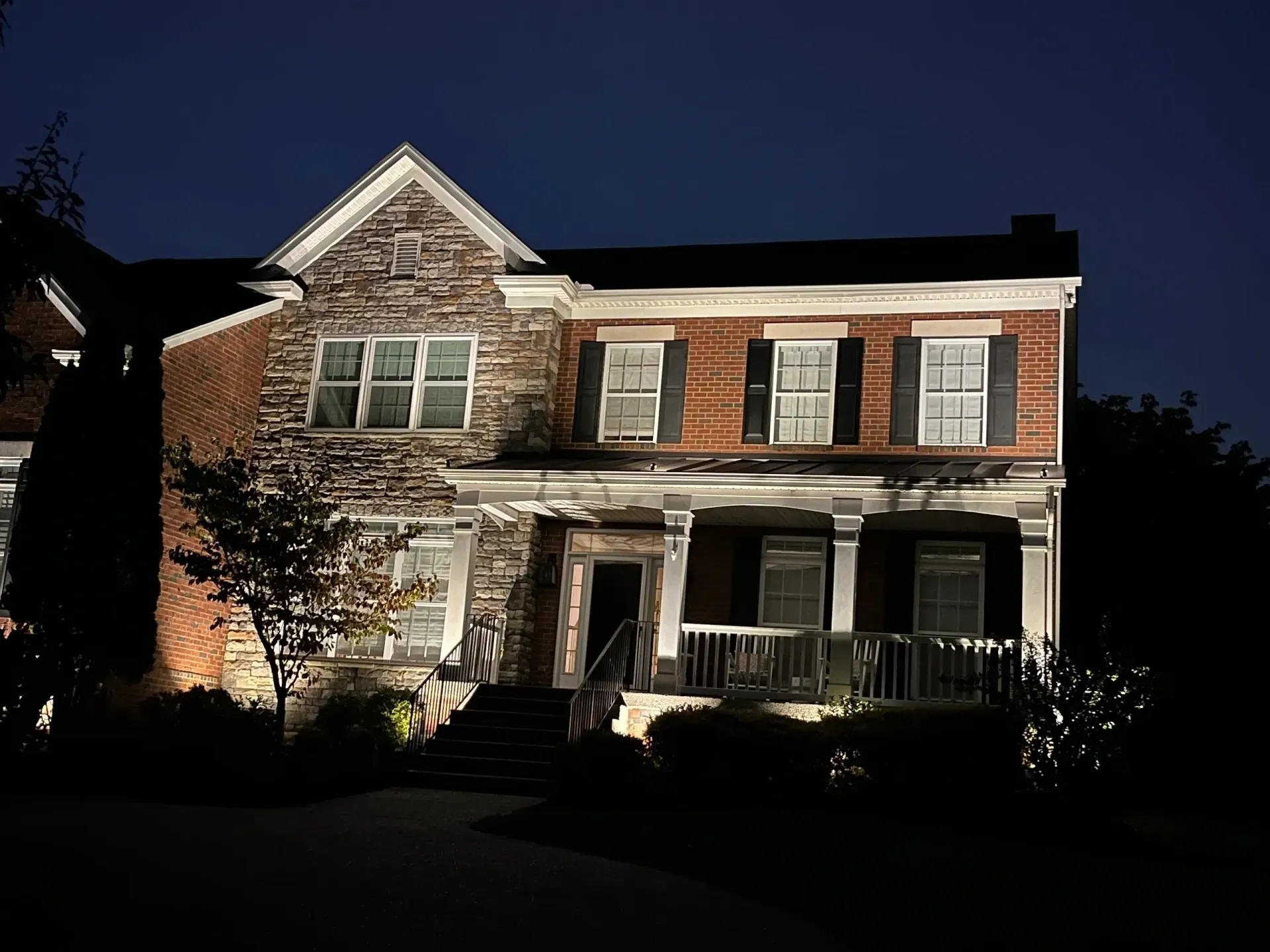 A large brick house is lit up at night.