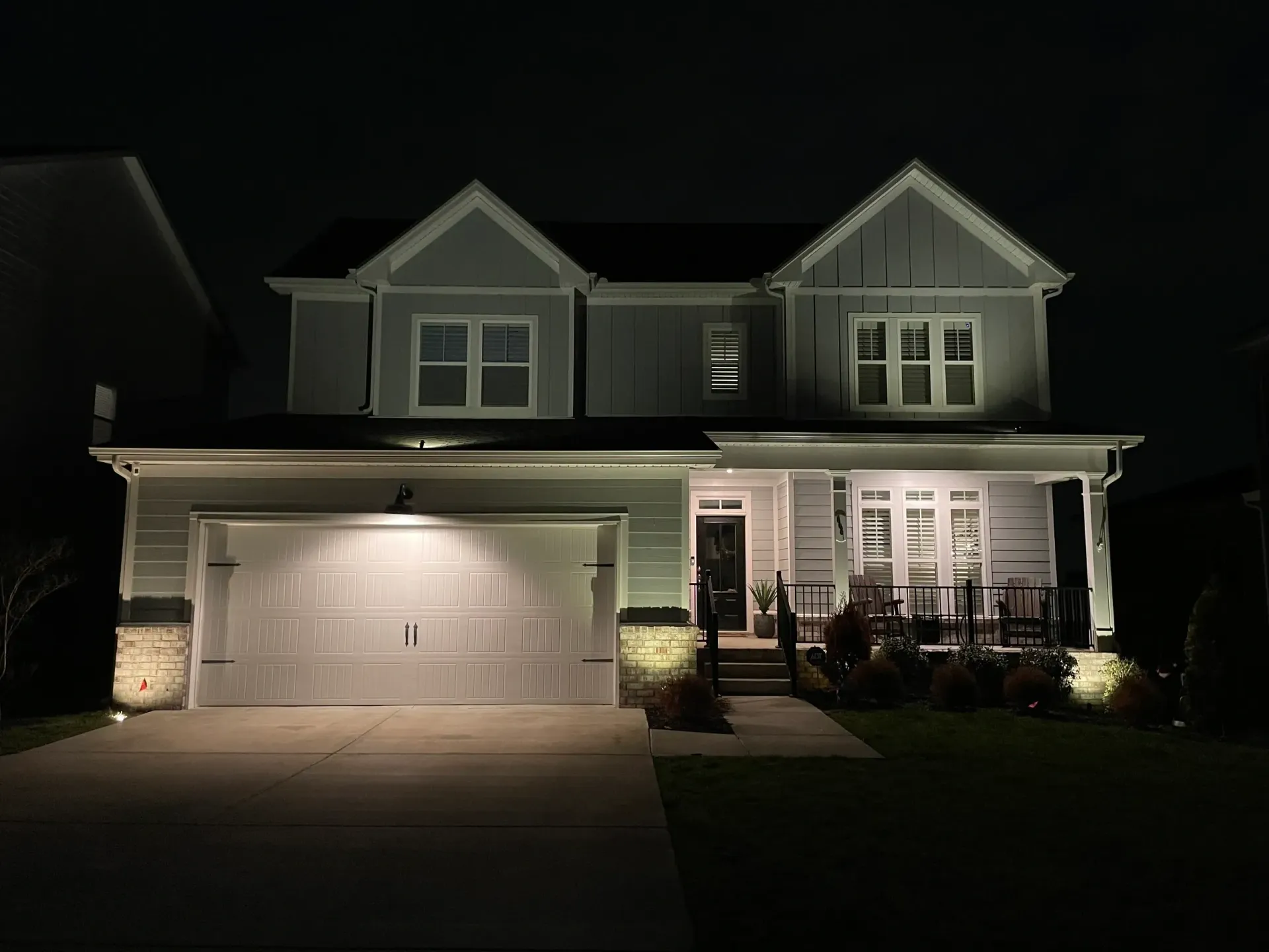 The front of a house is lit up at night.