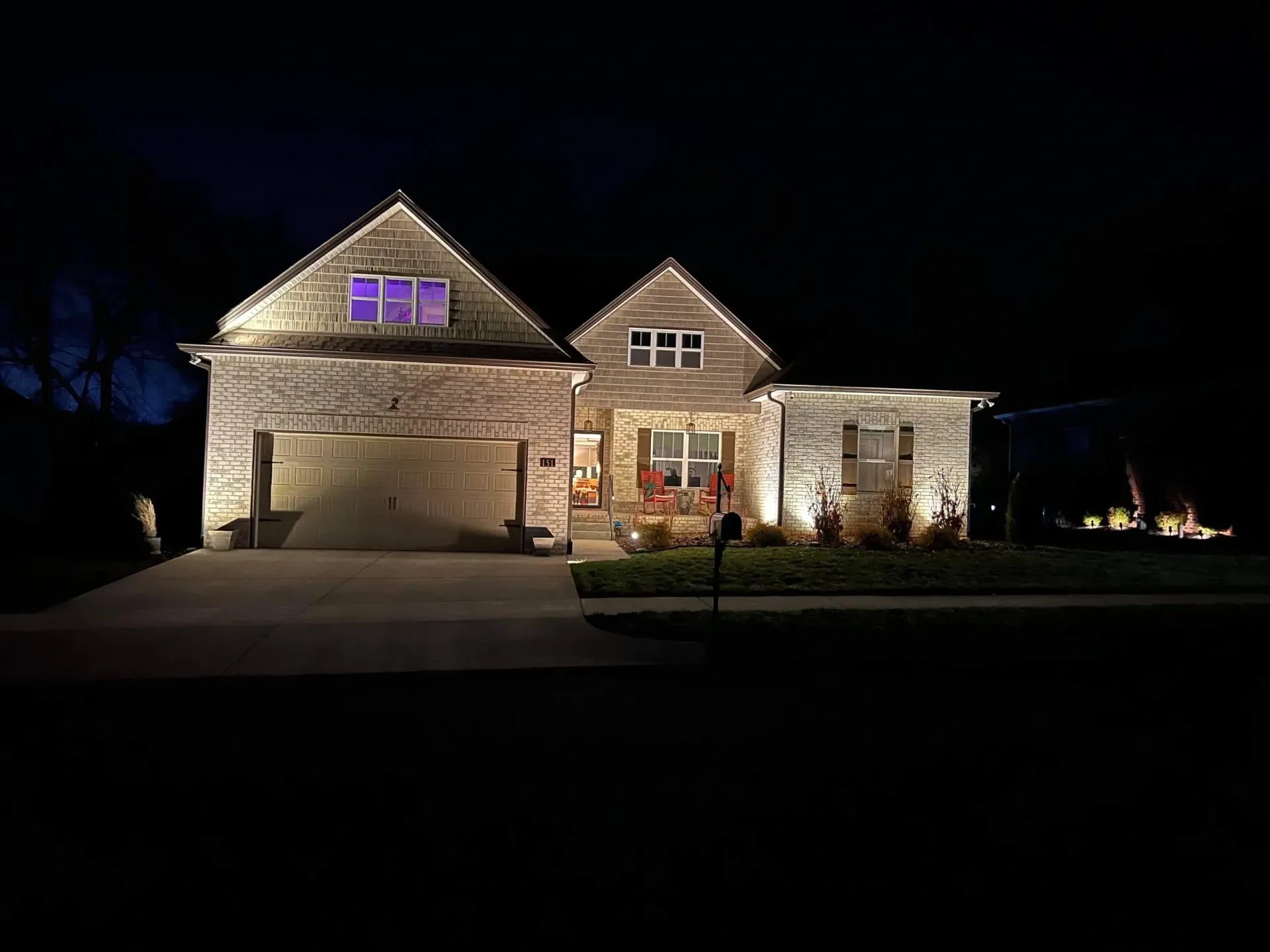 The front of a house is lit up at night.