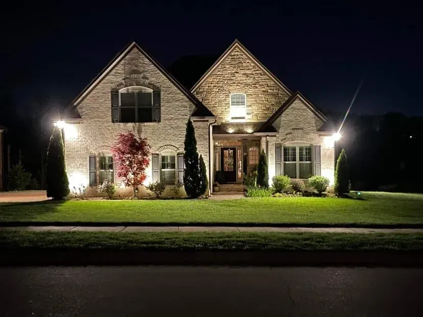 A large brick house is lit up at night.
