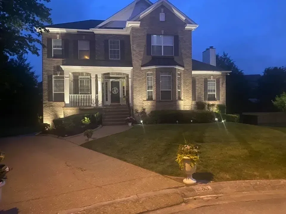 A large brick house is lit up at night.