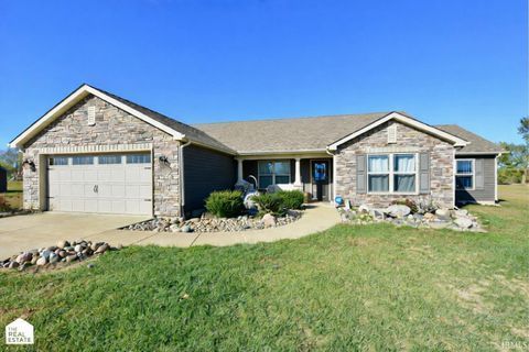 Exterior view of a ranch-style house with gray stone accents, garage, and blue sky.