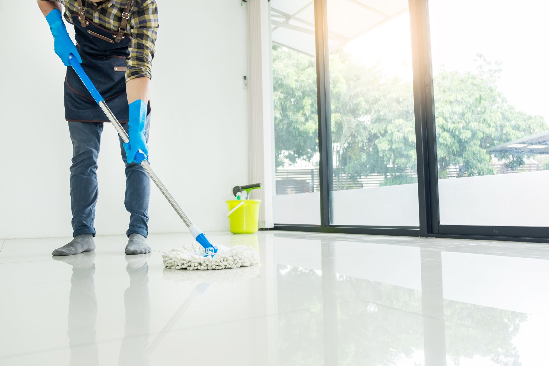 A man is cleaning the floor with a mop in a room.