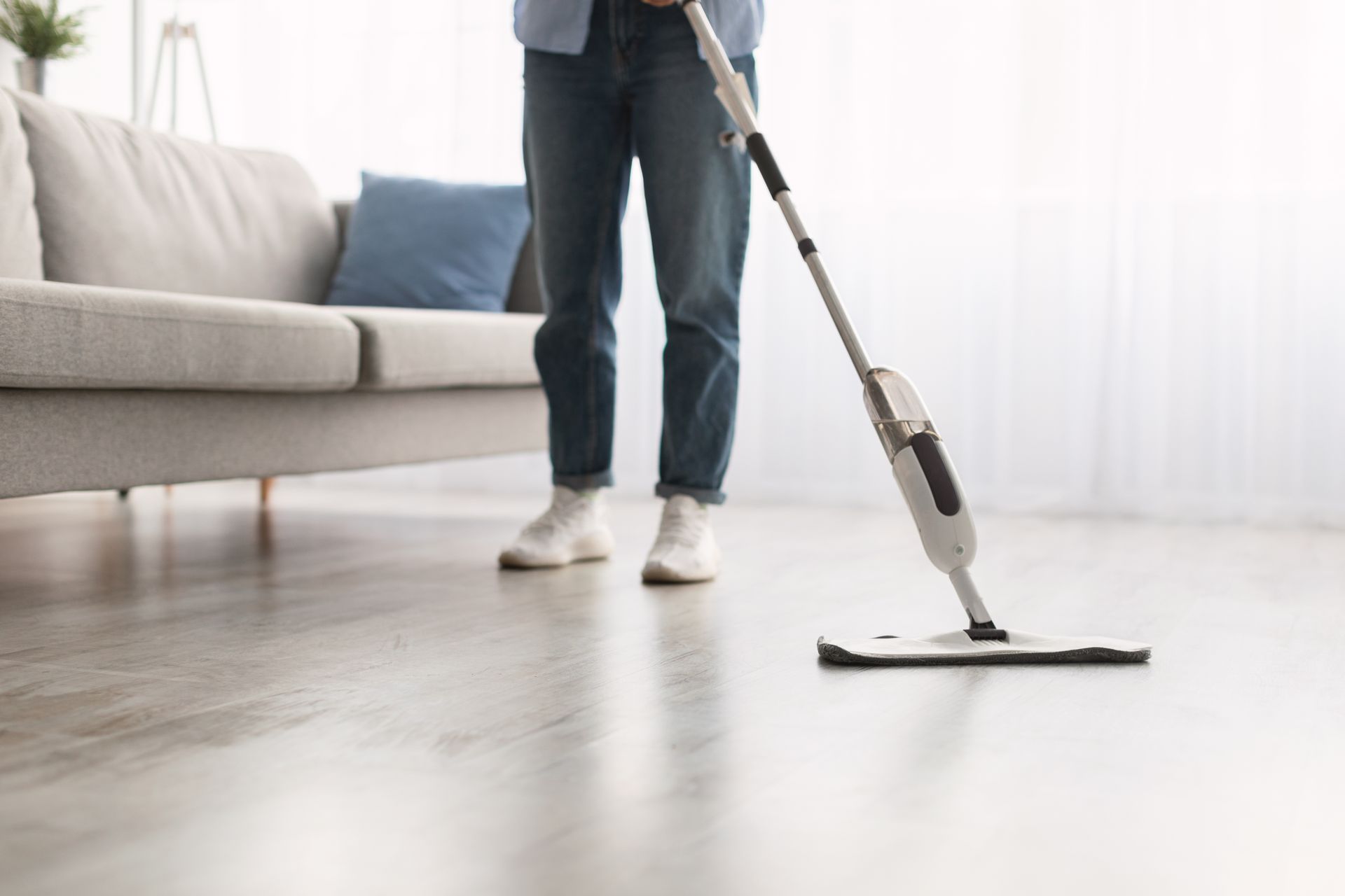 Woman efficiently cleaning the floor using a spray mop