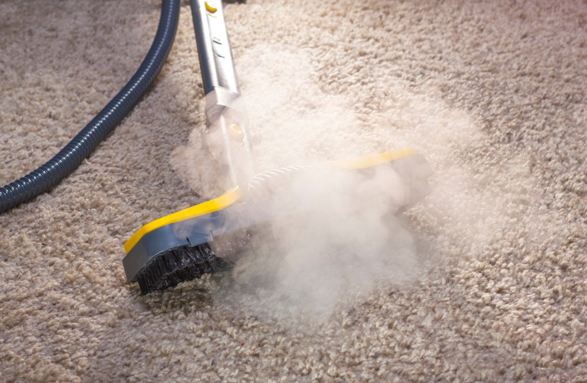 A vacuum cleaner is cleaning a carpet with smoke coming out of it.