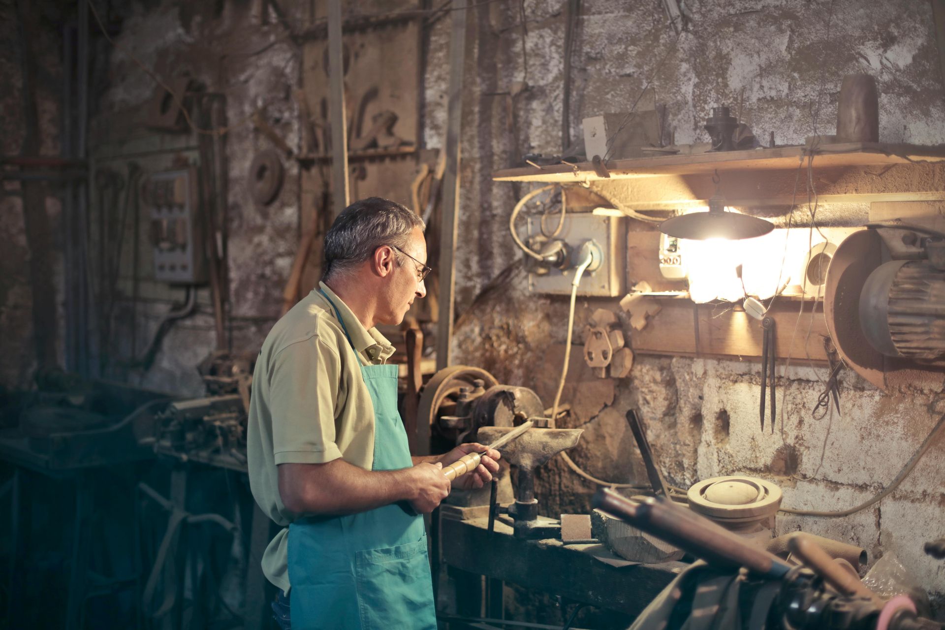 A man is working on a piece of metal in a workshop.