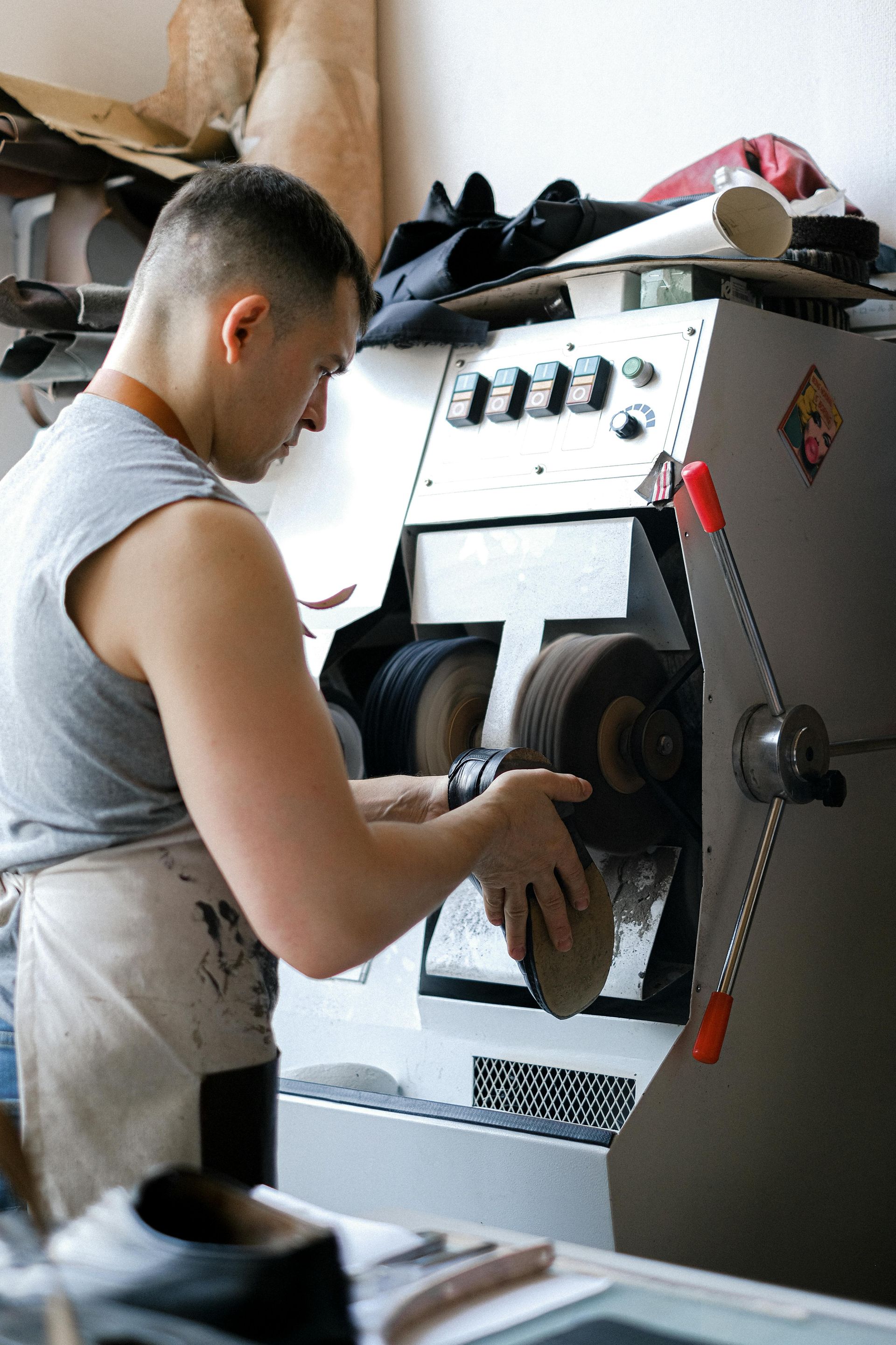 A man is polishing a shoe with a machine.
