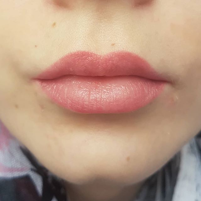 Eine Nahaufnahme der Lippen einer Frau mit rosa Lippenstift.